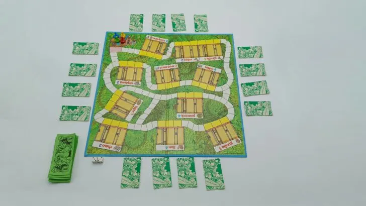 This picture shows how to setup a game of Even Elephants Forget, with face down cards around the game board, the money by the zookeeper acting as the "banker," and the playing pieces all on the starting space.