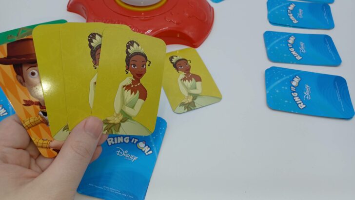 The player has picked up their hand with the three Tiana cards and will now swap their Woody card for the Tiana card they placed by the card tray.