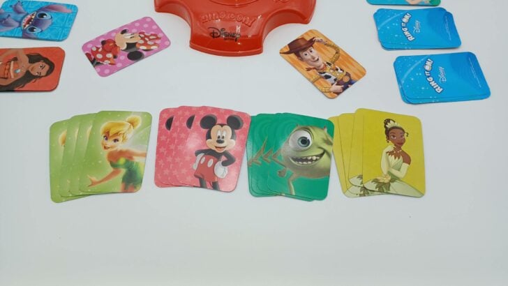 This picture shows a player with four completed sets: a set of four light green Tinker Bell cards, four red Mickey Mouse cards, four green Mike Wazowski cards, and the four Tiana cards from earlier. They have won the game!