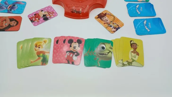 This picture shows a player with four completed sets: a set of four light green Tinker Bell cards, four red Mickey Mouse cards, four green Mike Wazowski cards, and the four Tiana cards from earlier. They have won the game!