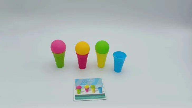 This player has matched the challenge card by getting the pink ice cream scoop into the green cone, the yellow scoop into the pink cone, the green scoop into the yellow cone, and leaving the blue cone blank.