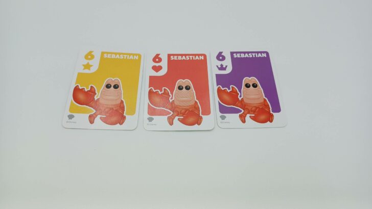 This picture shows a player scoring a set by having a yellow, red, and purple Sebastian card in front of them.