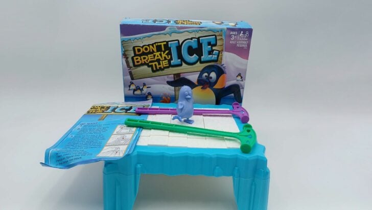 A picture of all of the components included in Don't Break the Ice: 32 small ice blocks, a large ice block, ice tray frame, 4 ice tray legs, Phillip the penguin figure, 2 mallets and instructions.