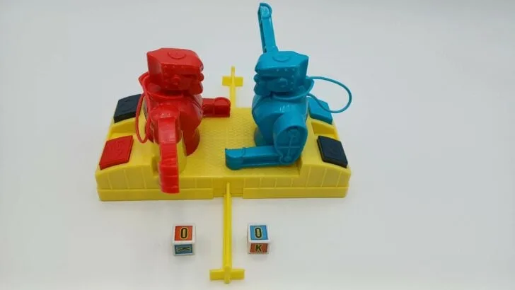 A picture of the setup for Rock 'em Sock 'em Robots: Knock or Block. The robots have been inserted into the game base, their arms have been swung out, and the dice decals have been applied.