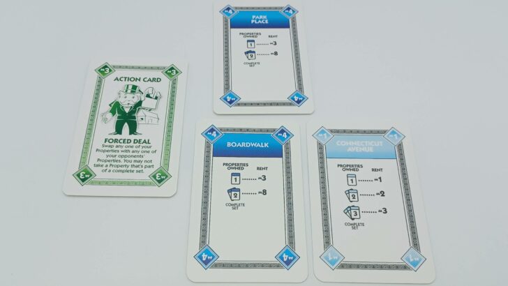 A player using a Forced Deal card to steal a card from another player.